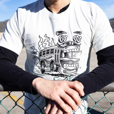 White t-shirt with large black outlined graphic of a cartoon character LaZoom bus with an open mouth and lights that look like surprised eyes